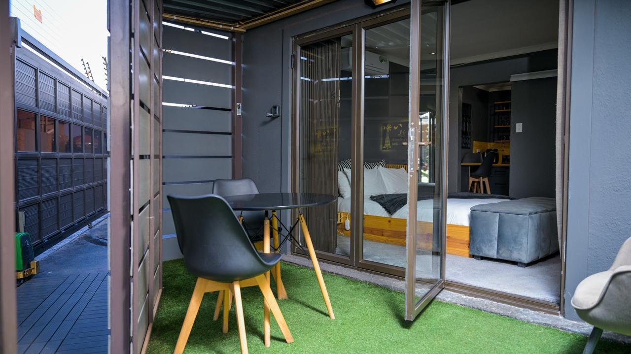 Guest room at House Of Nyibiba opening onto a private patio with outdoor seating
